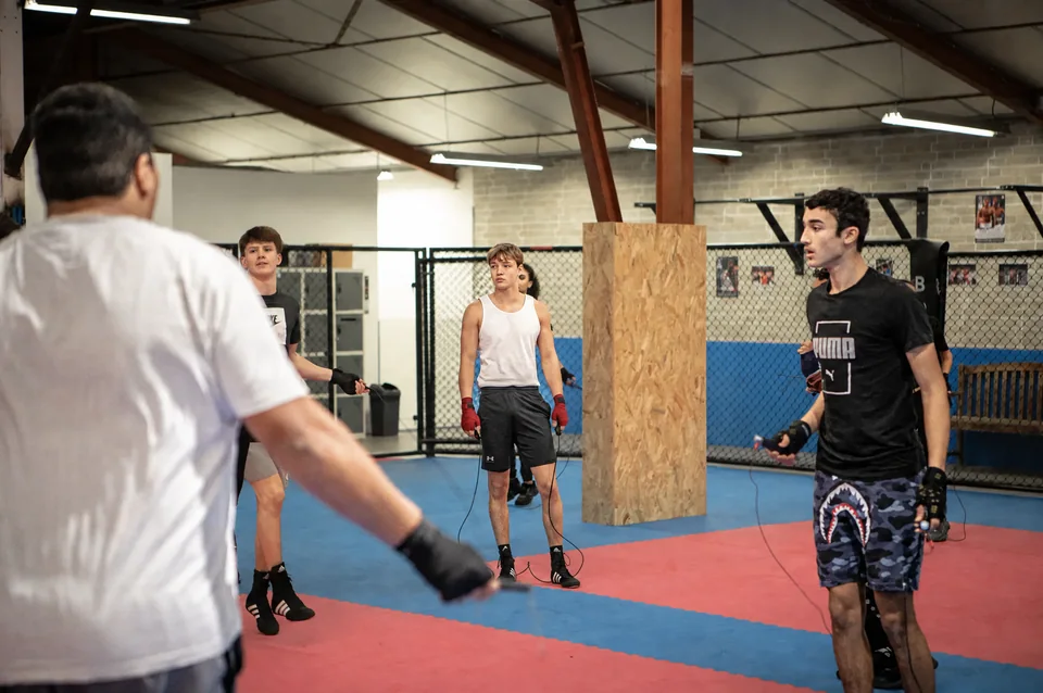 Club MMA proche de Blagnac : échauffement à la corde dans une salle Boxing Center équipée d’une cage.